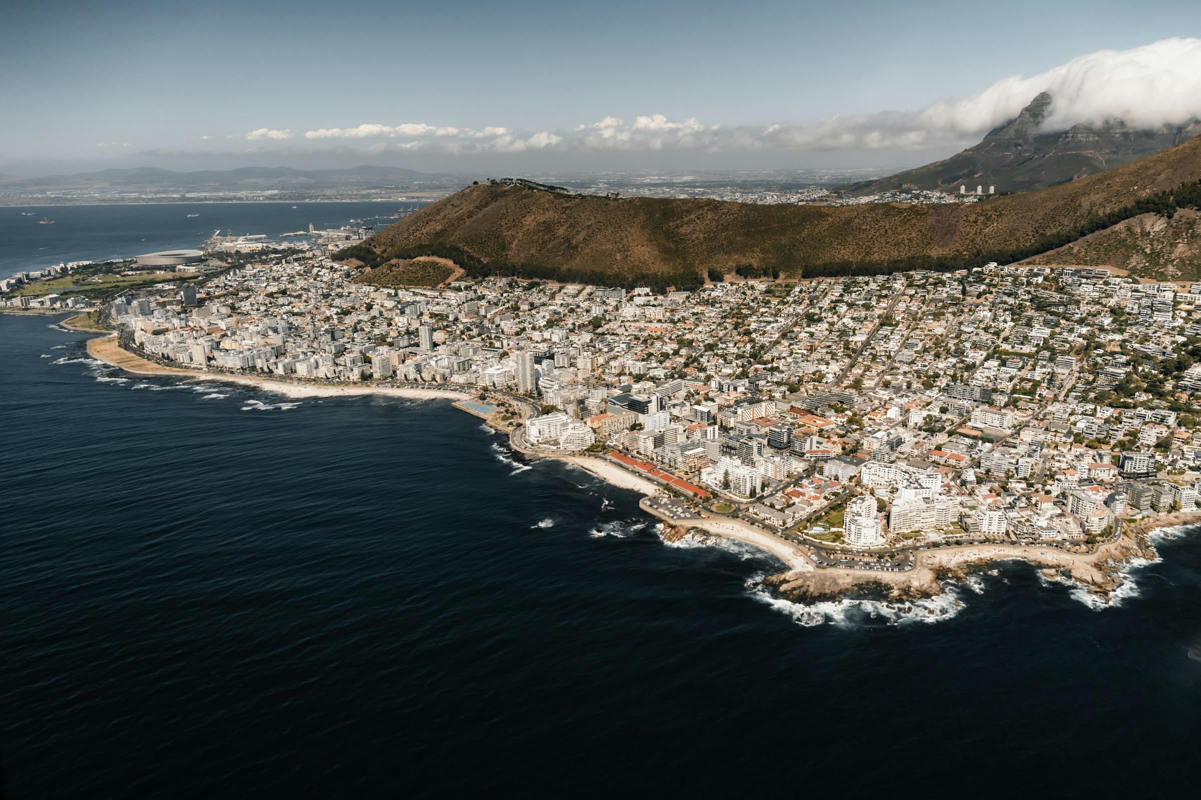 Cidade costeira vista do alto entre montanhas e oceano